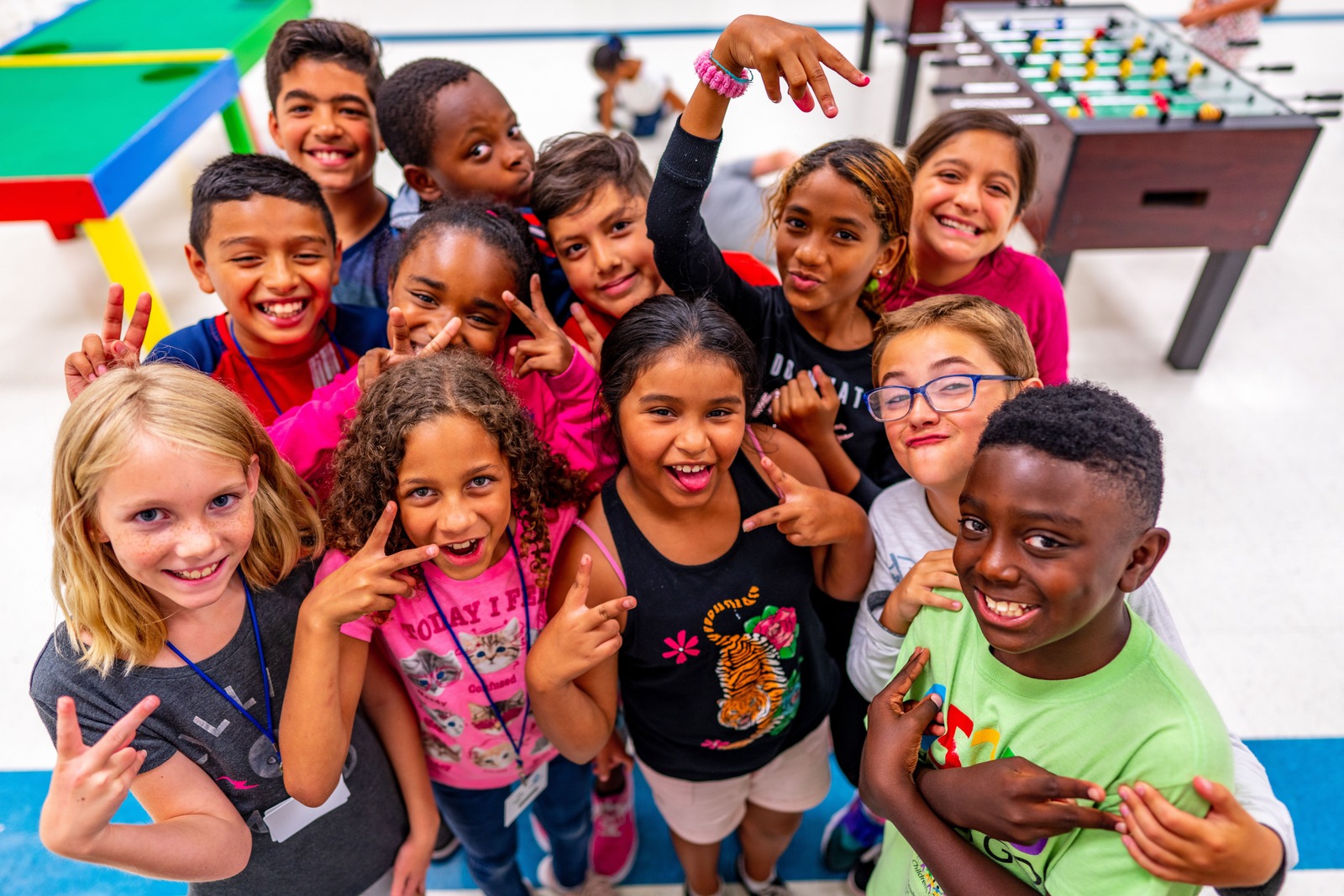 Smiling Club members gathered together in a Boys & Girls Club game room